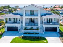 Stunning two-story waterfront home with a manicured lawn, dual garages, and multiple balconies at 2050 Hawaii Ne Ave, St Petersburg, FL 33703