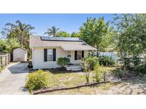 Charming home featuring a well-kept lawn, neutral paint, shutters and solar panels for energy efficiency at 2414 W State St, Tampa, FL 33609