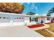 Charming single-story home with a well-maintained lawn, two-car garage, and mature landscaping at 2760 Kumquat Dr, Clearwater, FL 33759
