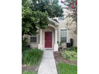 Charming home featuring a red front door, lush landscaping, and a welcoming walkway leading to the entrance at 30132 Wellesley Way, Wesley Chapel, FL 33543