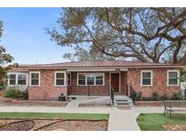 Charming brick home with a metal roof, landscaped yard and mature trees at 5010 45Th N Ave, St Petersburg, FL 33709