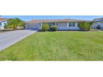 Well-maintained single story home with a green lawn and a two car garage with driveway at 607 Fox Hills Dr, Sun City Center, FL 33573