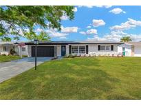 Charming single-story home with a well-manicured lawn and a driveway leading to a two-car garage at 11361 88Th Ave, Seminole, FL 33772