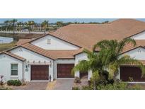 A beautiful exterior view of a well-maintained home with a tile roof and three-car garage at 16927 April Plush Dr, Wimauma, FL 33598