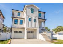 Modern white two-story home featuring a dual-car garage and elevated entry with sleek architectural details at 1745 Massachusetts Ne Ave, St Petersburg, FL 33703