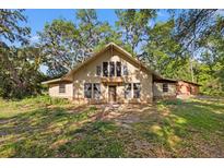 Charming home featuring a vaulted entryway, multiple windows, and a symmetrical design surrounded by mature trees at 308 N Smokey Mountain Rd, Seffner, FL 33584