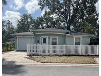 Charming single-story home featuring a well-maintained lawn and a classic white picket fence at 3211 E 23Rd Ave, Tampa, FL 33605