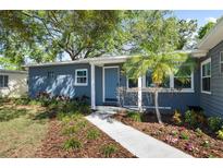 Charming home featuring a blue exterior, complemented by lush landscaping and a well-manicured front yard at 4105 W Fair Oaks Ave, Tampa, FL 33611