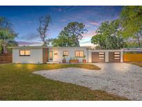 Charming single-story home with modern wood accents, a gravel driveway, and a well-manicured front lawn at 4925 Camellia S Way, St Petersburg, FL 33705