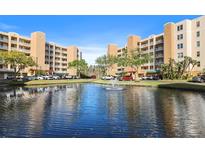 Beautiful condo buildings overlook a tranquil pond with a fountain and manicured landscaping at 6495 Shoreline Dr # 8106, St Petersburg, FL 33708