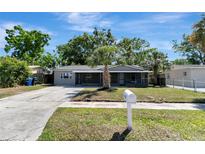 Charming single-story home with a well-maintained lawn and mature palm tree in the front yard at 7101 Kingston Dr, Tampa, FL 33619