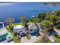 Stunning aerial view of lakefront home with lush landscaping and private dock access at 1162 Tookes Rd, Tarpon Springs, FL 34689