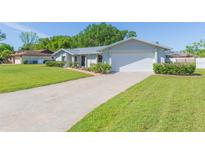 Well-maintained single-Gathering home with a two-car garage and manicured lawn at 12208 Elsmere Ct, Thonotosassa, FL 33592