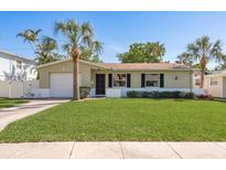 Charming single-story home with a well-manicured lawn and mature palm trees at 146 82Nd N Ave, St Petersburg, FL 33702