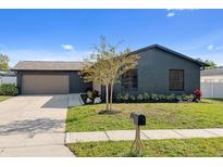 Charming home exterior with dark brick, a well-manicured lawn, and a welcoming driveway at 1981 Briarwood St, Dunedin, FL 34698