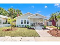 Charming single-story home featuring a cozy front porch, manicured lawn, and mature landscaping at 2328 Dartmouth N Ave, St Petersburg, FL 33713