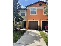 Charming townhome featuring a one car garage and colorful stucco exterior at 2520 Edgewater Falls Dr, Brandon, FL 33511