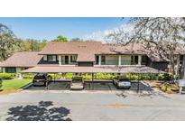 Two-story home with a covered carport and well-maintained landscaping with mature trees and shrubs, providing ample shade at 3610 Magnolia Ridge Cir # 1322/H, Palm Harbor, FL 34684