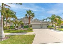 Charming single-story home with a well-manicured lawn and lush tropical landscaping, enhancing its curb appeal at 5409 Conch Shell Pl, Apollo Beach, FL 33572