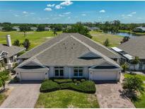 Beautiful home with two-car garages, brick driveway, manicured landscaping, and an expansive lawn at 604 Mcdaniel St, Sun City Center, FL 33573