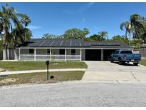 Charming single-story home with a well-manicured lawn, solar panels and a white picket fence enhancing its curb appeal at 804 Valley Hill Ct, Brandon, FL 33510