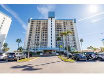Stunning high-rise condo building showcasing a clean design with multiple balconies and lush palm tree landscaping at 9415 Blind Pass Rd # 704, St Pete Beach, FL 33706