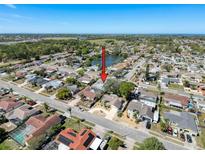 Aerial view of the neighborhood, showcasing the home's location near a lake and green spaces at 1102 Springtime Dr, Holiday, FL 34691