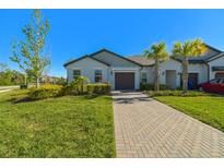 Charming single-story home with a well-manicured lawn, paver driveway, and mature landscaping at 16710 Shell Bay Dr, Land O Lakes, FL 34638