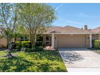 Charming single-story home with a well-manicured lawn, mature trees, and a two-car garage at 2312 Heron Cir, Clearwater, FL 33762
