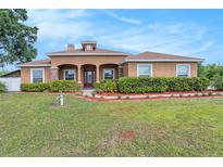 Beautiful single-story home featuring a well-manicured lawn and stucco exterior with stone column accents at 260 Moccasin Hollow Rd, Lithia, FL 33547