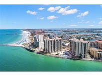 Beautiful aerial view of beachfront condos on the sandy shore with aqua water and blue skies at 440 S Gulfview Blvd # 1701, Clearwater Beach, FL 33767