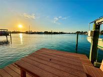 Waterfront dock featuring a seating area and beautiful views of the surrounding water and sunset at 540 115Th Ave, Treasure Island, FL 33706