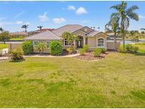 Inviting home featuring manicured landscaping, a tile roof, and a circular driveway, surrounded by lush greenery at 6181 9Th Avenue Ne Cir, Bradenton, FL 34212