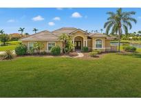 Beautiful single Gathering home with a well manicured green lawn, a brown roof, and a lake view at 6181 9Th Avenue Ne Cir, Bradenton, FL 34212