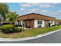 Charming single-story home with a palm tree, landscaped yard, and stylish stone accents on the facade at 6188 Chesham Dr # 5, New Port Richey, FL 34653