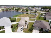 Aerial view of a home with a white fence, waterfront view, and attached two-car garage at 6632 Laxey Ct, Zephyrhills, FL 33541