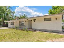 Charming, single story home featuring white brick and well-manicured lawn with exterior lights at 904 Woodland Dr, Seffner, FL 33584