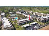 Overhead view of the condo complex with a pool, tennis court, and covered parking at 12300 Vonn Rd # 2204, Largo, FL 33774