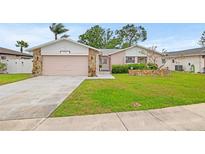 Charming single-story home featuring a well-maintained lawn and a two-car garage at 12762 98Th St, Largo, FL 33773