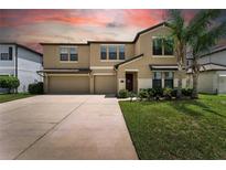 Charming two-story home featuring a two-car garage, landscaped yard, and welcoming front entrance at 14050 Arbor Pines Dr, Riverview, FL 33579