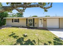 Charming single-story home with a well-manicured lawn and mature landscaping at 1764 St Croix Dr, Clearwater, FL 33759