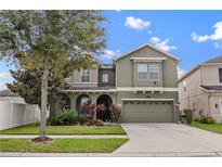 Charming two-story home featuring a well-manicured lawn and a two-car garage, providing curb appeal at 19214 Early Violet Ne Dr, Tampa, FL 33647