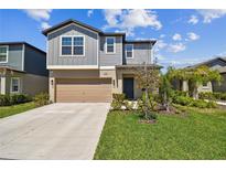 Charming two-story home with a well-manicured lawn and attached two-car garage at 22287 Storybook Cabin Way, Land O Lakes, FL 34637