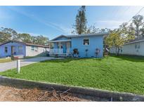 Charming light blue home featuring a well-maintained lawn and inviting front porch at 2418 N Links Ave, Sarasota, FL 34234