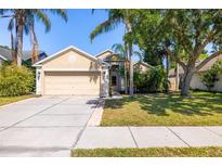Inviting home with lush landscaping, mature trees, and a well-maintained lawn at 29013 Old Marsh End, Wesley Chapel, FL 33543