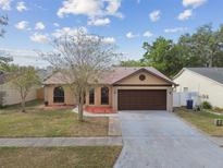 Charming single-story home featuring a well-maintained lawn, two-car garage, and decorative landscaping at 2974 Sean Way, Palm Harbor, FL 34684