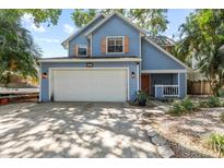 Charming blue two-story home featuring a wide driveway and attached two-car garage at 3710 W Tacon St, Tampa, FL 33629