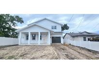 Charming two-story home with a covered front porch and an attached garage at 745 31St N Ave, St Petersburg, FL 33704