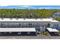 This condo building features covered parking, a flat roof, and many mature trees at 7700 92Nd St # 207, Seminole, FL 33777