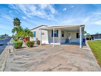 Charming single-story home with a carport, landscaped yard, and mature palm trees at 109 W Saint Lucia Loop, Apollo Beach, FL 33572